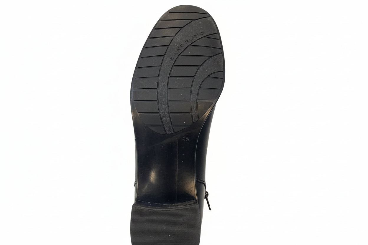 Black shoe sole with tread pattern on a concrete floor