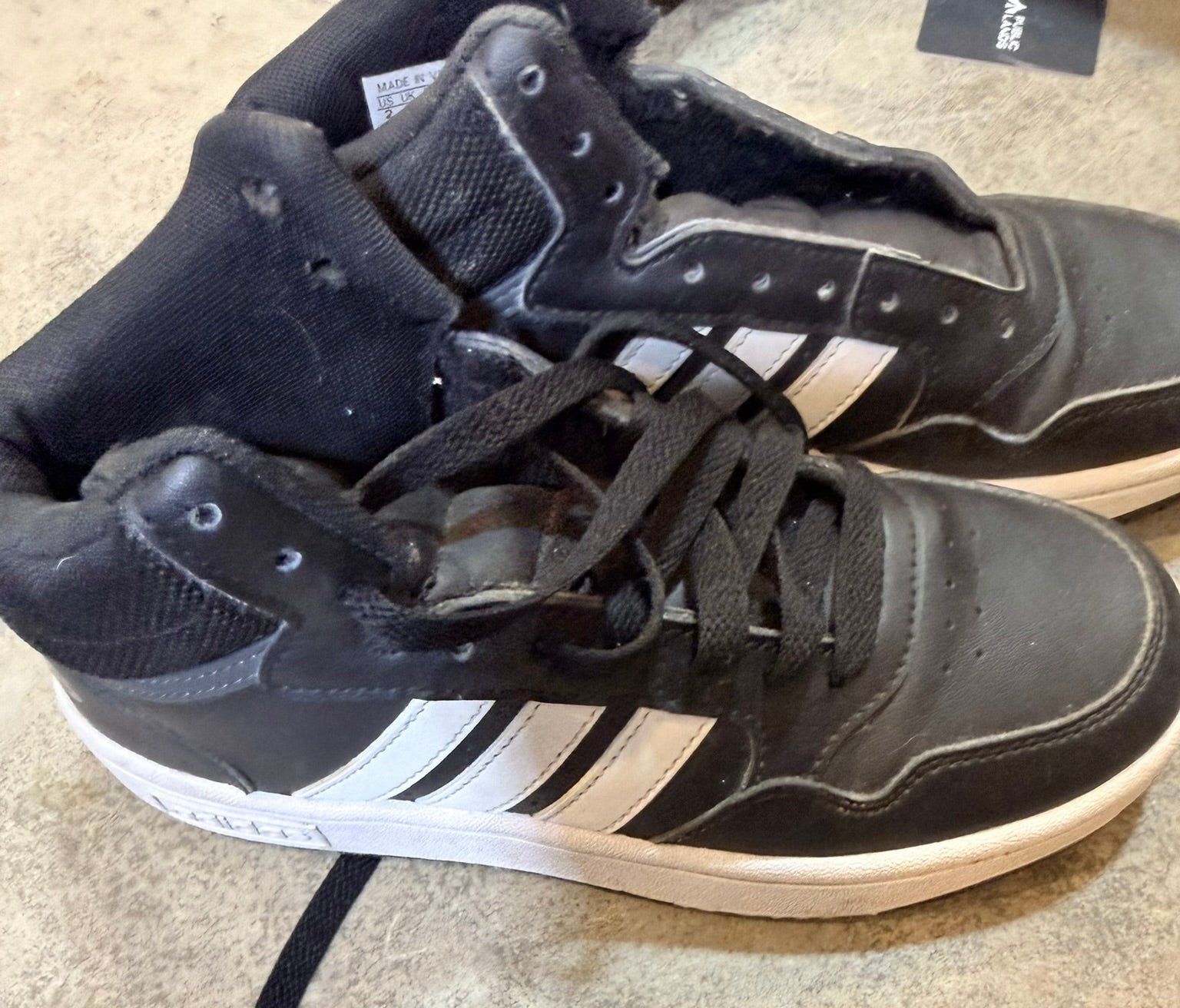 Black Adidas sneakers with white stripes