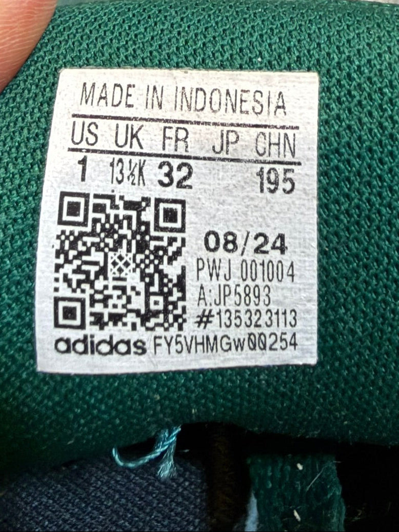 Green sneaker with a label and QR code on a textured surface