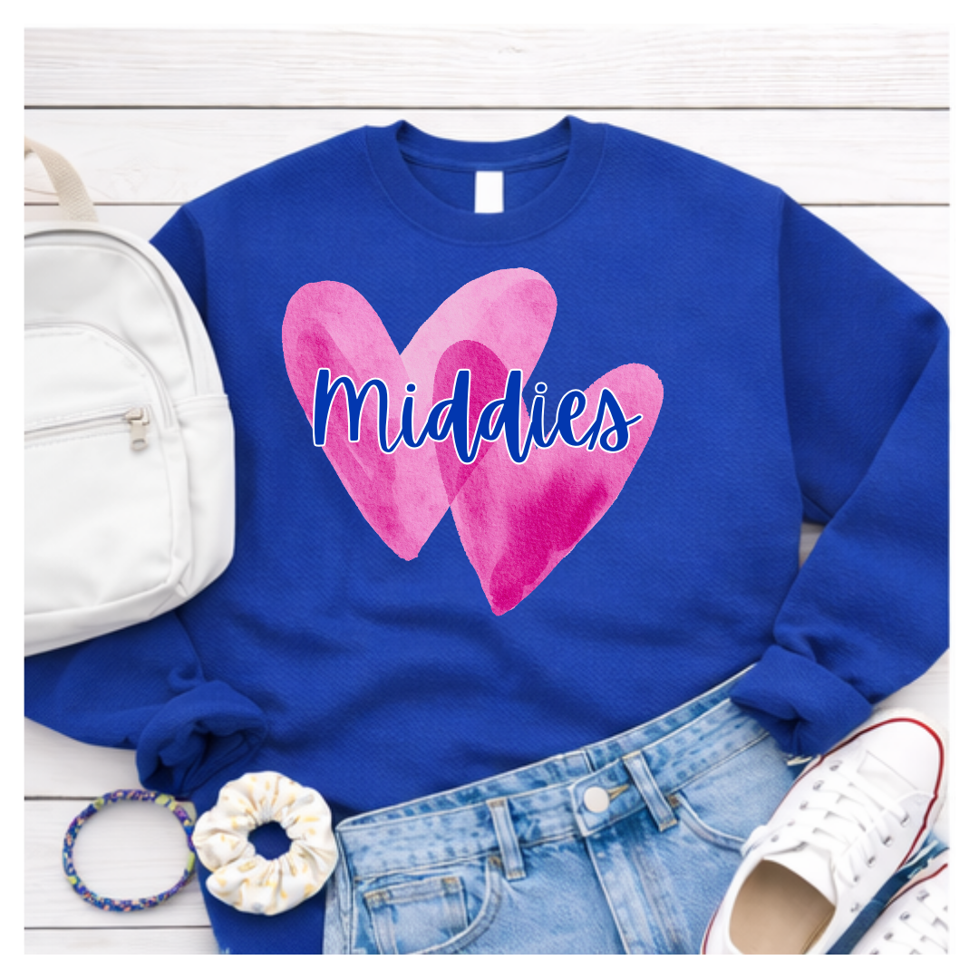 Blue sweatshirt with pink hearts and 'Middies' text, displayed with accessories on a white wooden surface.