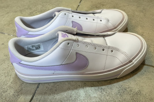 Pair of light purple sneakers on a concrete floor.