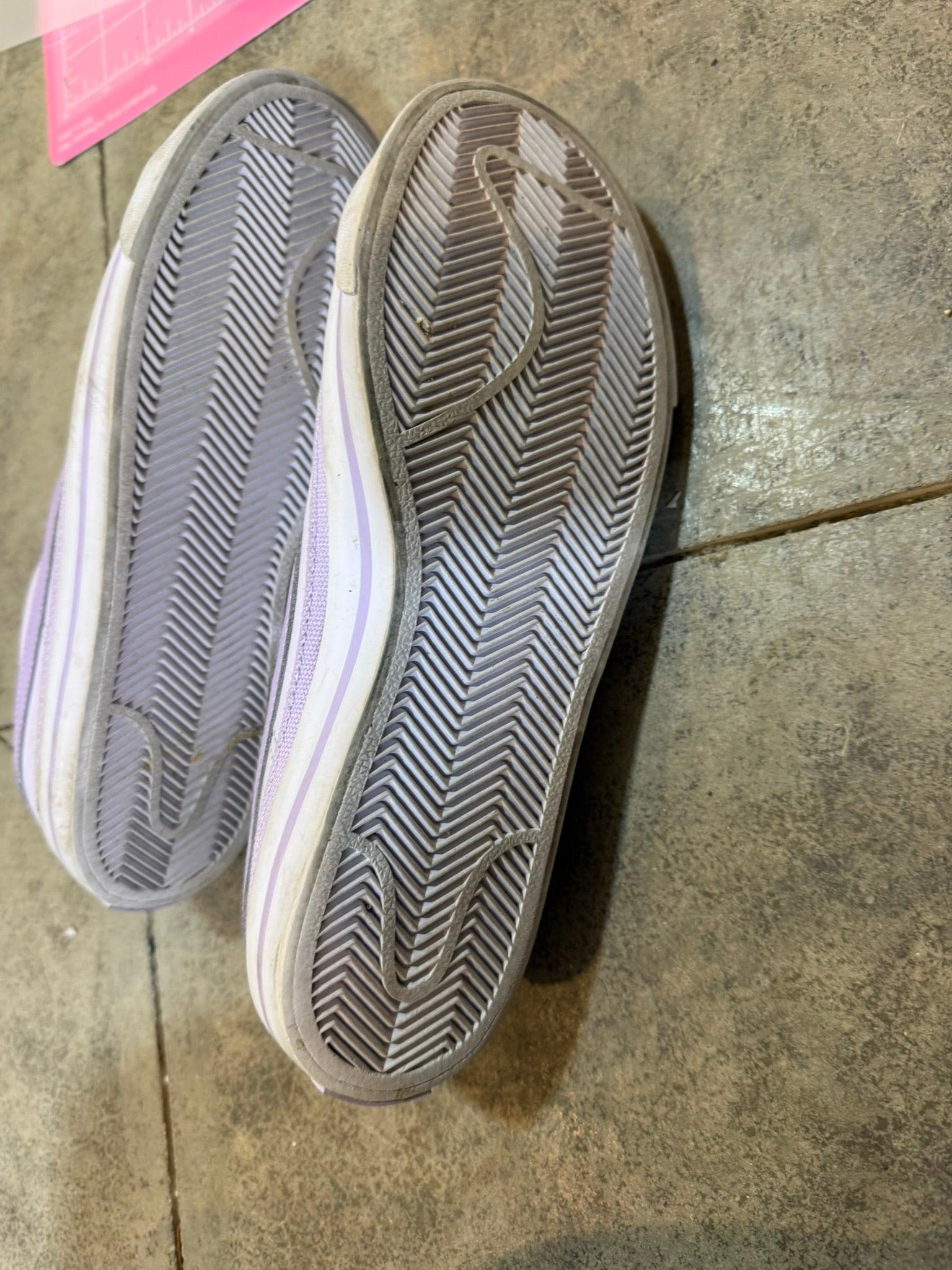 Close-up of a pair of shoes on a concrete floor.